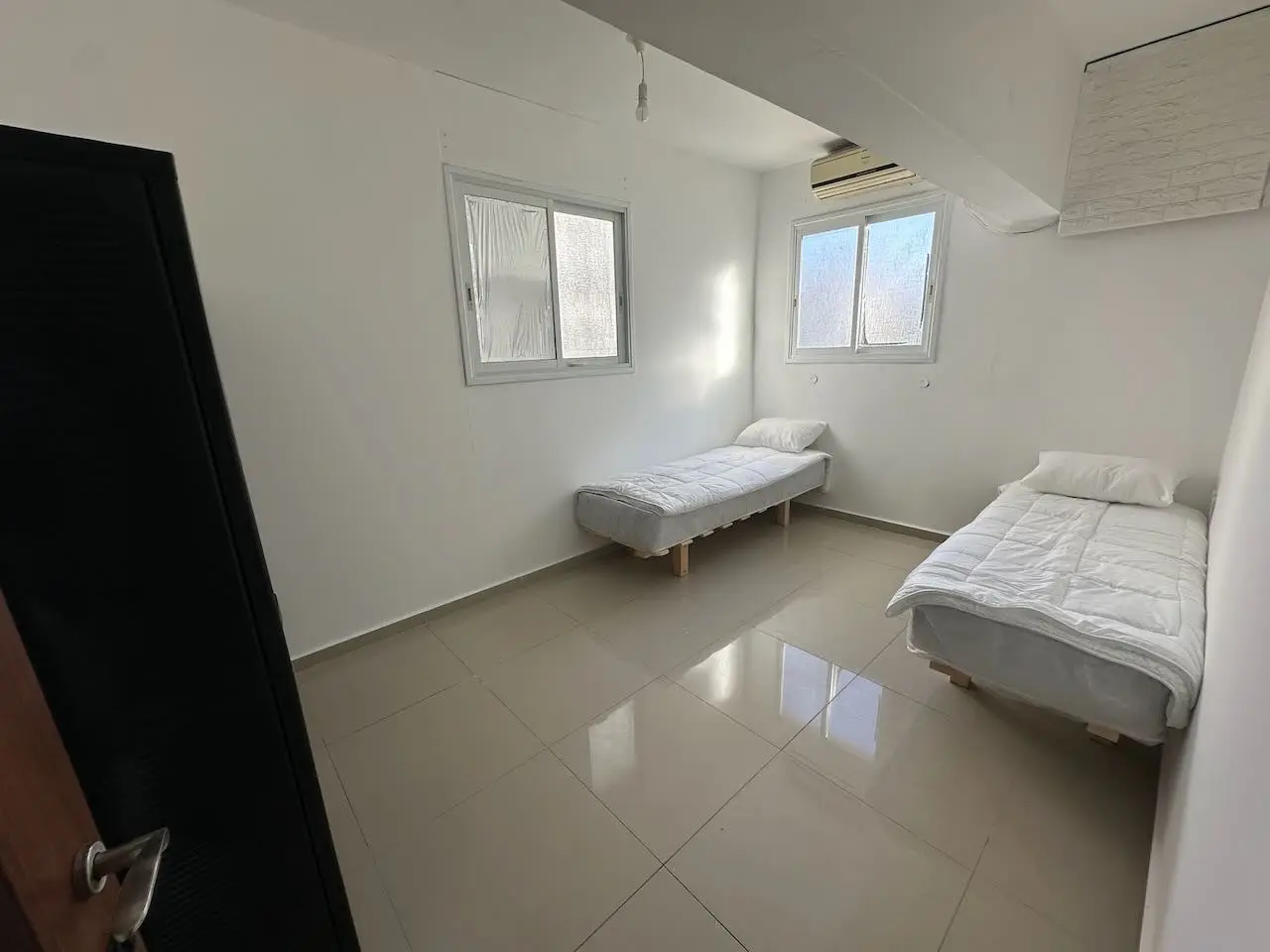 חדר שינה במגורי עובדי פאנטום — מיטות מוצעות ומזגן