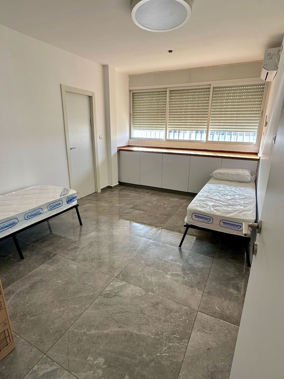 חדר עם שתי מיטות וארונות אחסון במגורי העובדים