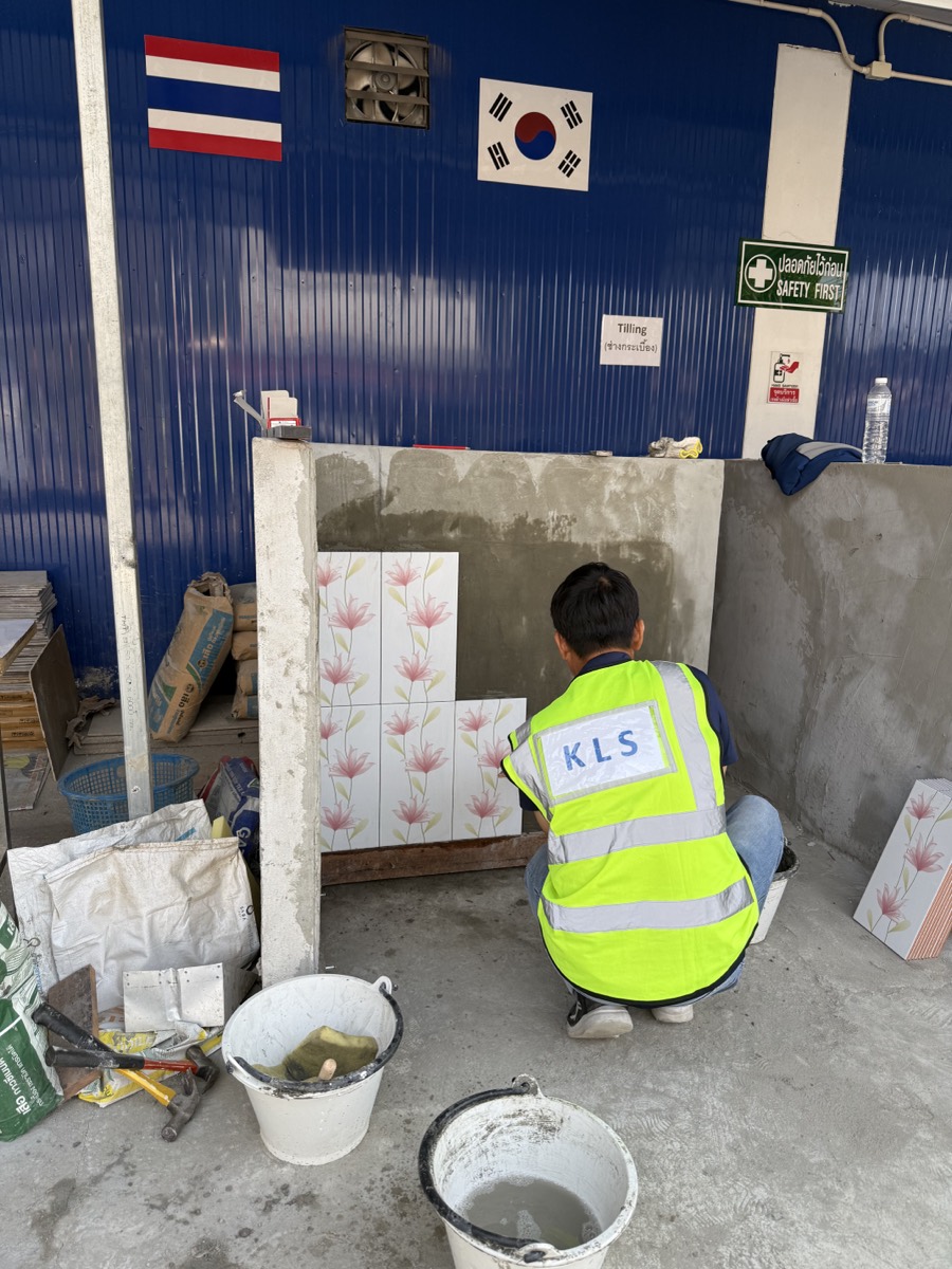 מועמד בעבודת ריצוף וחיפוי אריחים במהלך מבחן מעשי לפני הגעה לישראל